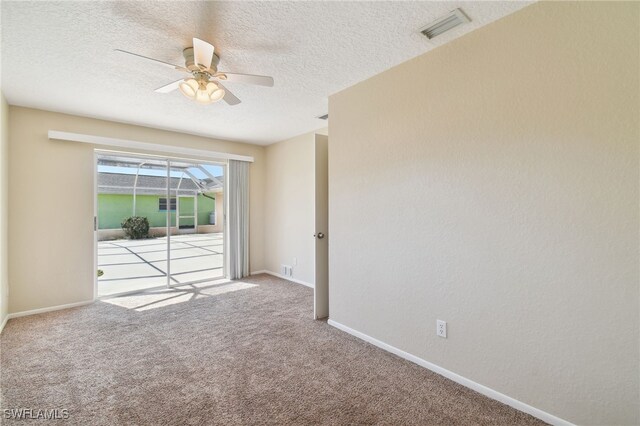 spare room featuring ceiling fan, light colored carpet, and a textured ceiling