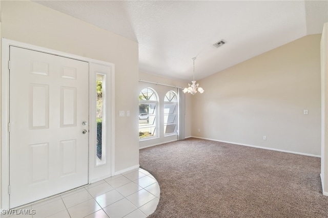 carpeted entryway featuring lofted ceiling and a chandelier