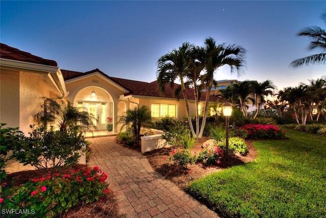 view of front of house with a yard and french doors