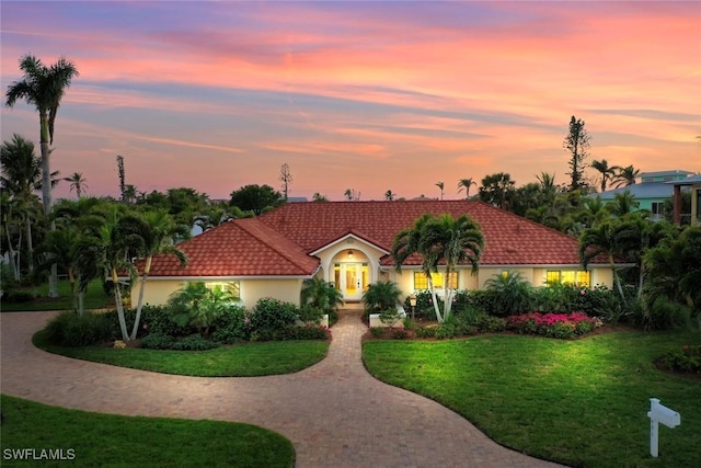 mediterranean / spanish house featuring a lawn