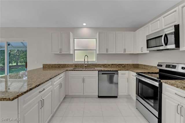 kitchen with sink, kitchen peninsula, white cabinets, and appliances with stainless steel finishes