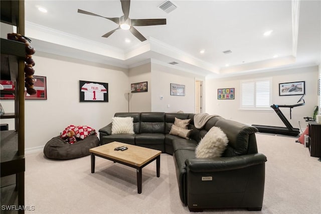 living room with crown molding, ceiling fan, a tray ceiling, and light carpet