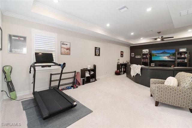 interior space with ornamental molding, ceiling fan, and a tray ceiling