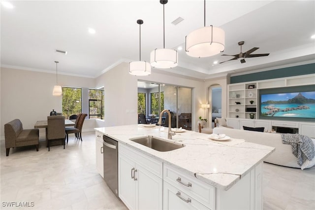 kitchen with dishwasher, sink, white cabinets, hanging light fixtures, and a kitchen island with sink