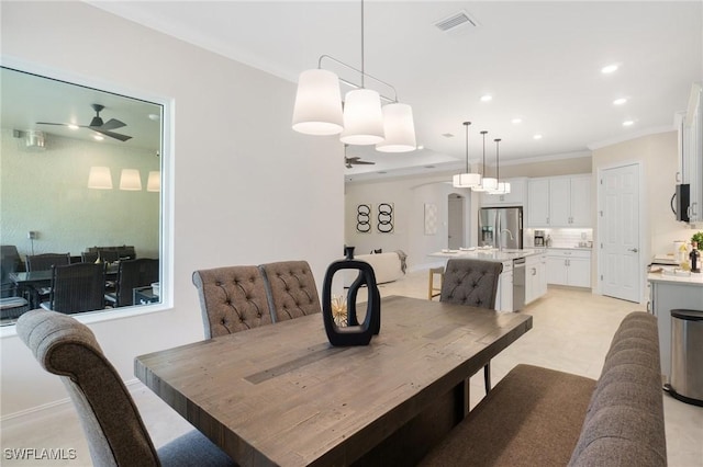 dining room featuring sink, ornamental molding, and ceiling fan