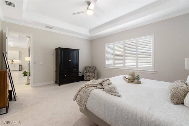 bedroom with carpet floors, ornamental molding, a raised ceiling, and ceiling fan