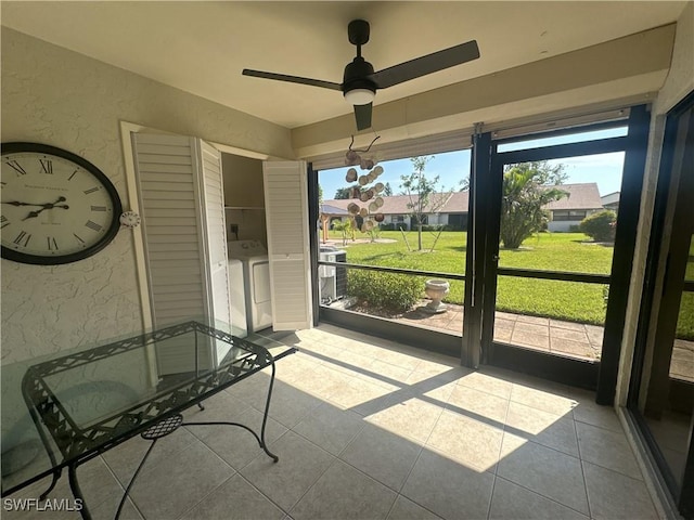 unfurnished sunroom with ceiling fan and washer and clothes dryer