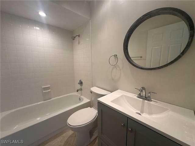 full bathroom featuring tiled shower / bath, vanity, toilet, and tile patterned floors