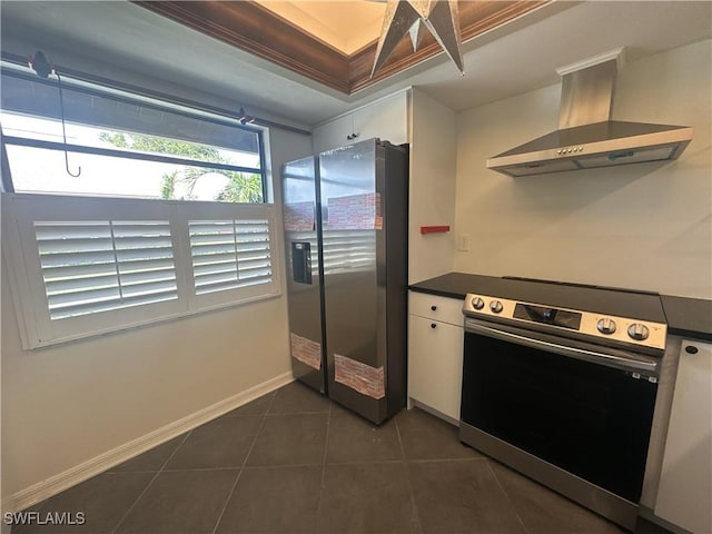 kitchen featuring stainless steel appliances, white cabinets, dark tile patterned flooring, and range hood