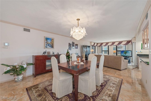 dining area with ornamental molding and a chandelier