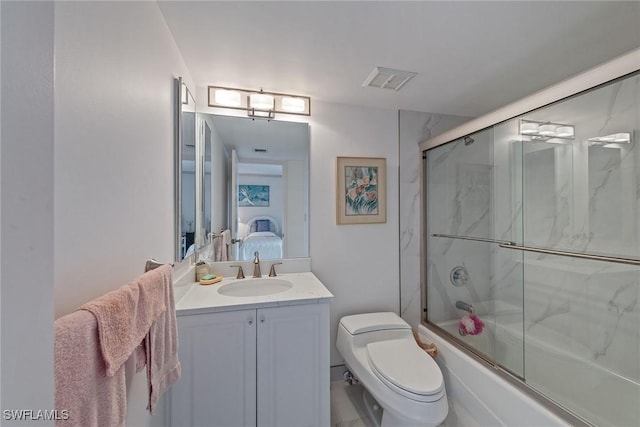 full bathroom featuring vanity, combined bath / shower with glass door, and toilet