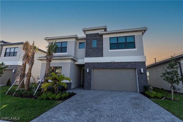 20341 Fair Oak Ln, Estero, FL 33928 - view of front of home featuring stucco siding, an attached garage, decorative driveway, and stone siding