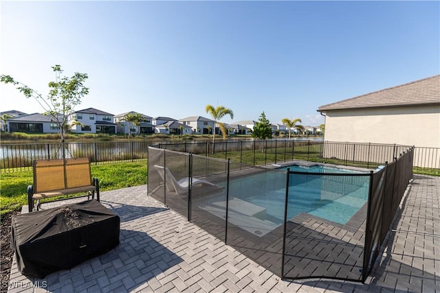 view of swimming pool featuring a water view and a patio