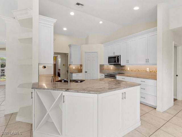 kitchen featuring a peninsula, a sink, visible vents, white cabinetry, and appliances with stainless steel finishes