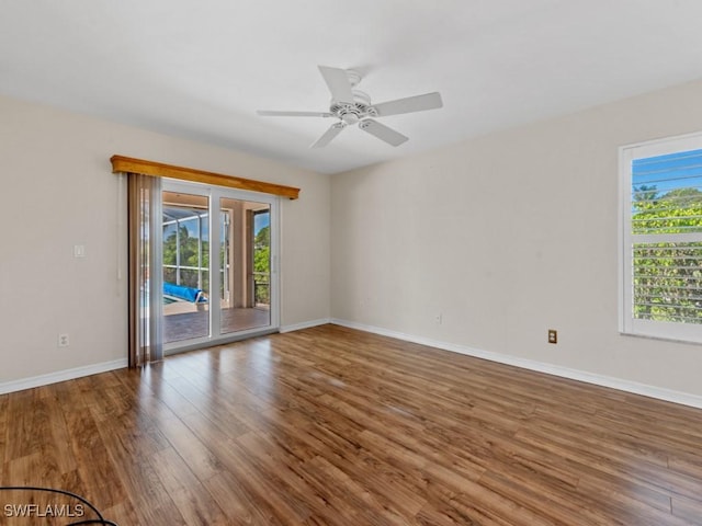 empty room featuring a ceiling fan, baseboards, and wood finished floors