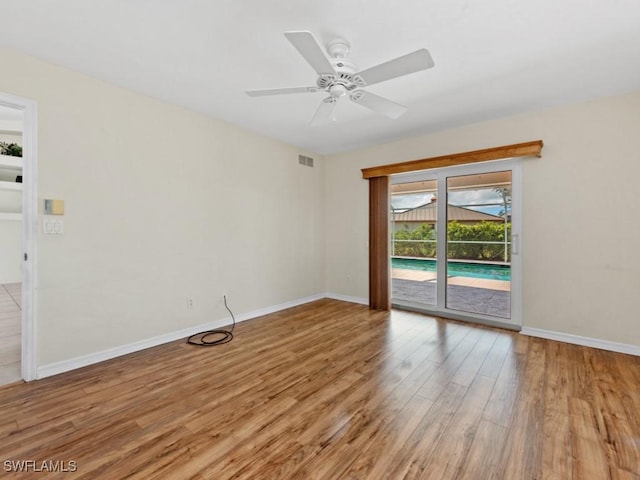 spare room featuring light wood-style flooring, visible vents, ceiling fan, and baseboards