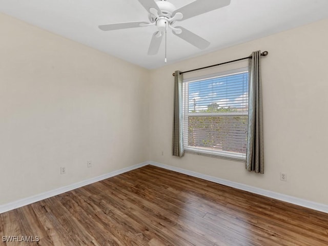 spare room featuring ceiling fan, baseboards, and wood finished floors