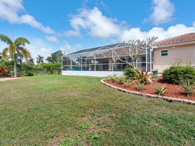 view of yard featuring glass enclosure and fence