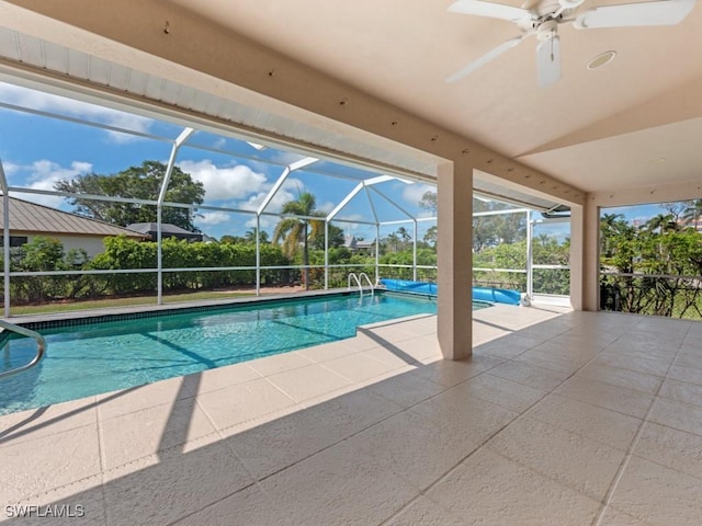 pool featuring glass enclosure, a patio area, and ceiling fan