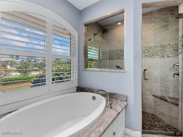 full bath featuring a stall shower and a garden tub