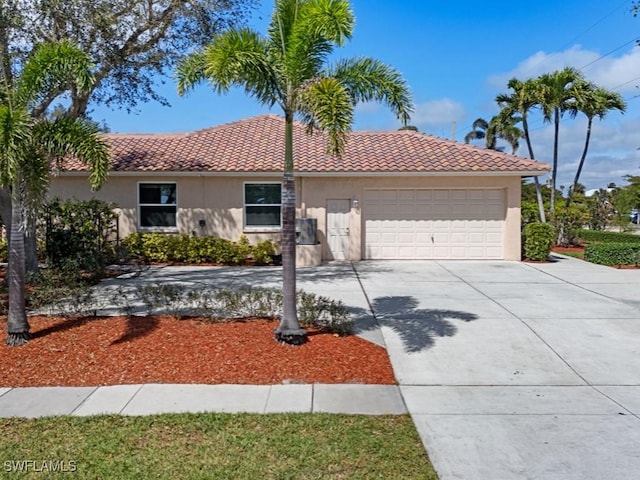 view of front facade with a garage, driveway, a tile roof, and stucco siding