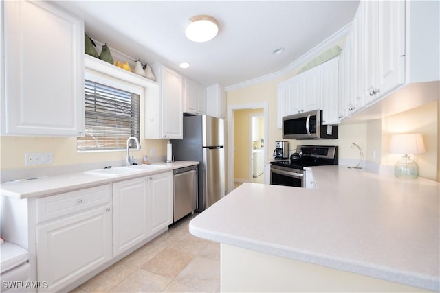 kitchen with appliances with stainless steel finishes, kitchen peninsula, sink, and white cabinets