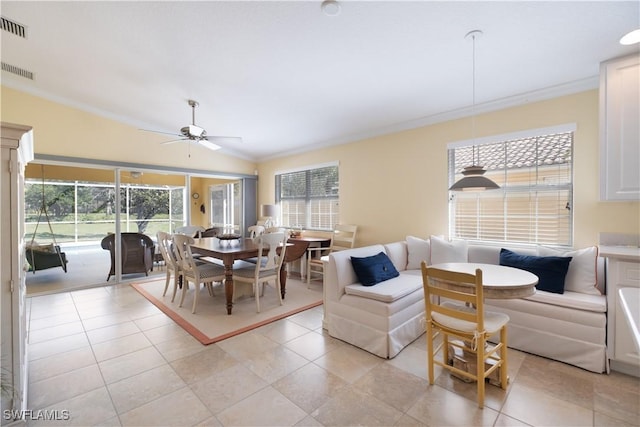 dining space featuring crown molding, ceiling fan, and light tile patterned floors