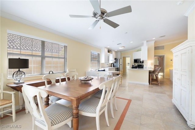 tiled dining area featuring crown molding and ceiling fan