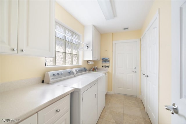 clothes washing area with cabinets, washing machine and dryer, sink, and light tile patterned floors