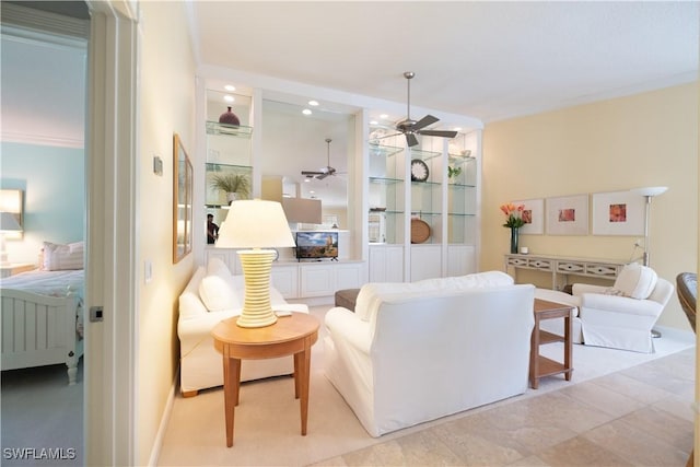 living room with ornamental molding and ceiling fan