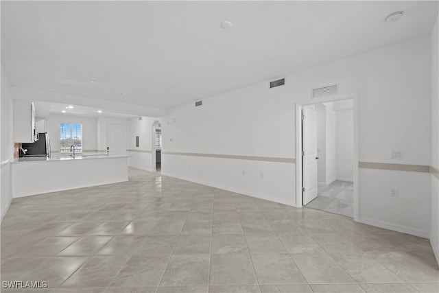 unfurnished living room featuring sink