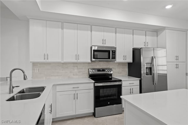 kitchen featuring appliances with stainless steel finishes, sink, white cabinets, decorative backsplash, and light tile patterned floors