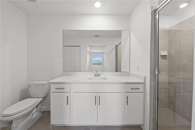 bathroom featuring vanity, tile patterned flooring, a shower with shower door, and toilet