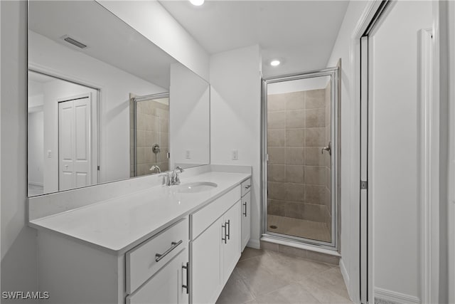 bathroom featuring vanity, tile patterned flooring, and walk in shower