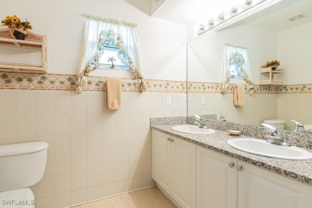 bathroom with plenty of natural light, tile walls, tile patterned floors, and toilet