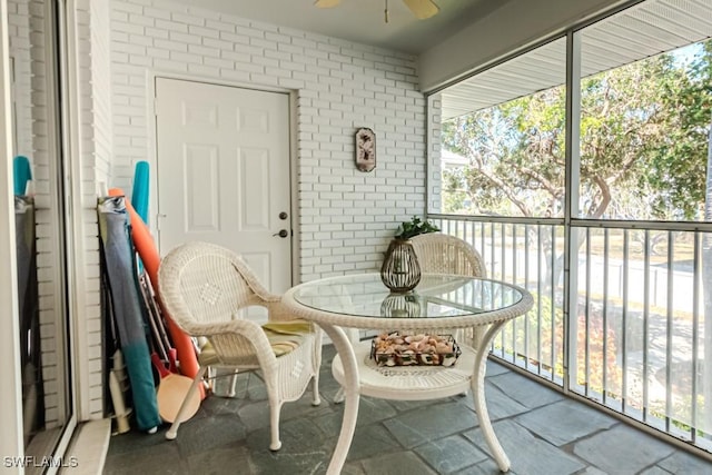 sunroom / solarium with a healthy amount of sunlight and ceiling fan