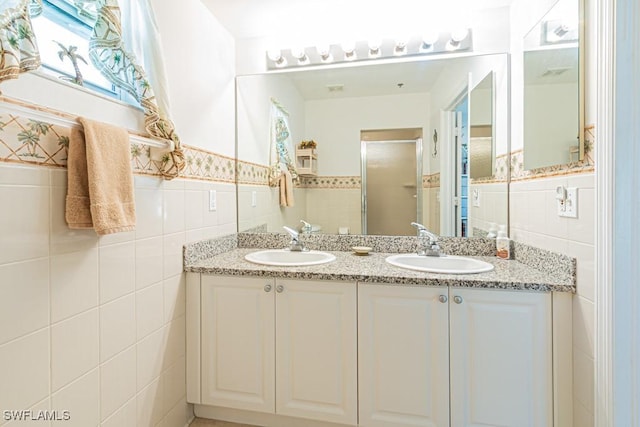 bathroom featuring vanity, a shower with door, and tile walls