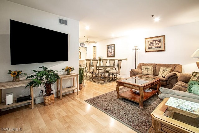 living room with light hardwood / wood-style floors and ceiling fan