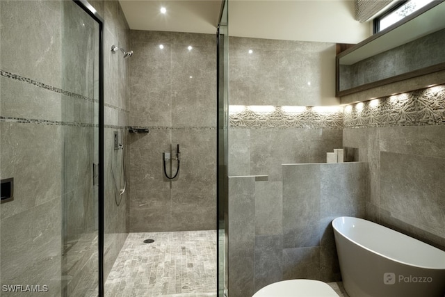 800 S Golf Dr Unit N205, Naples, FL 34102 - full bath featuring a shower stall, a freestanding tub, toilet, and tile walls