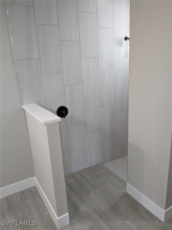 bathroom featuring walk in shower and baseboards
