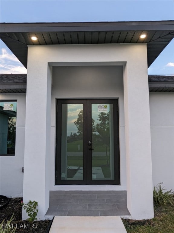 entrance to property featuring stucco siding and french doors