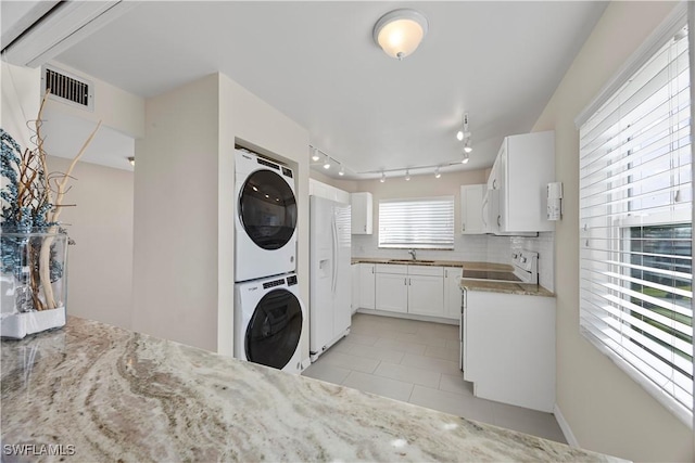 4372 27th Ct SW Unit 301, Naples, FL 34116 - washroom featuring stacked washer / drying machine, light tile patterned flooring, track lighting, and a sink
