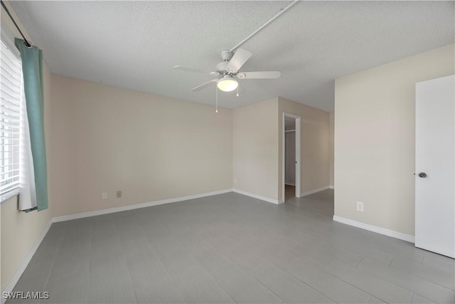 4372 27th Ct SW Unit 301, Naples, FL 34116 - spare room featuring a ceiling fan, a textured ceiling, and baseboards