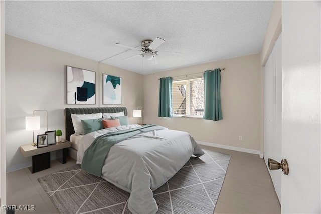 4372 27th Ct SW Unit 301, Naples, FL 34116 - bedroom featuring a textured ceiling, baseboards, and a ceiling fan