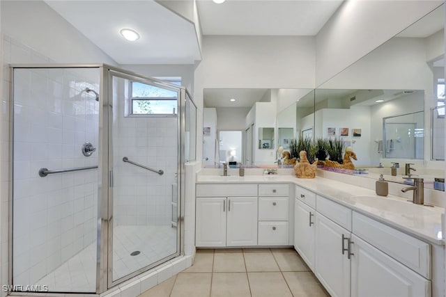 bathroom featuring tile patterned floors, a shower with shower door, and vanity