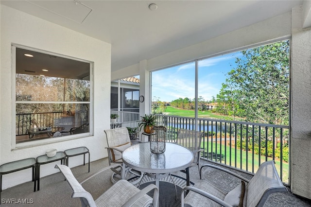 sunroom / solarium featuring a water view