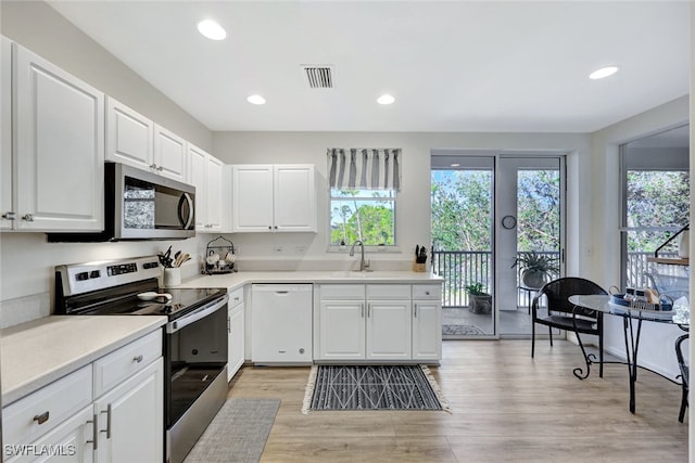 kitchen with white cabinetry, appliances with stainless steel finishes, plenty of natural light, and light wood-type flooring