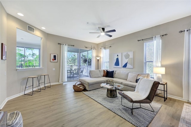 living room with ceiling fan, a healthy amount of sunlight, and light hardwood / wood-style flooring