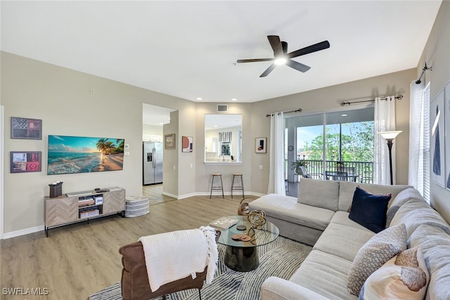 living room with light hardwood / wood-style floors and ceiling fan