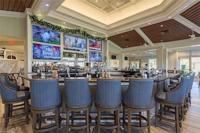 bar with crown molding, coffered ceiling, light hardwood / wood-style floors, and a towering ceiling